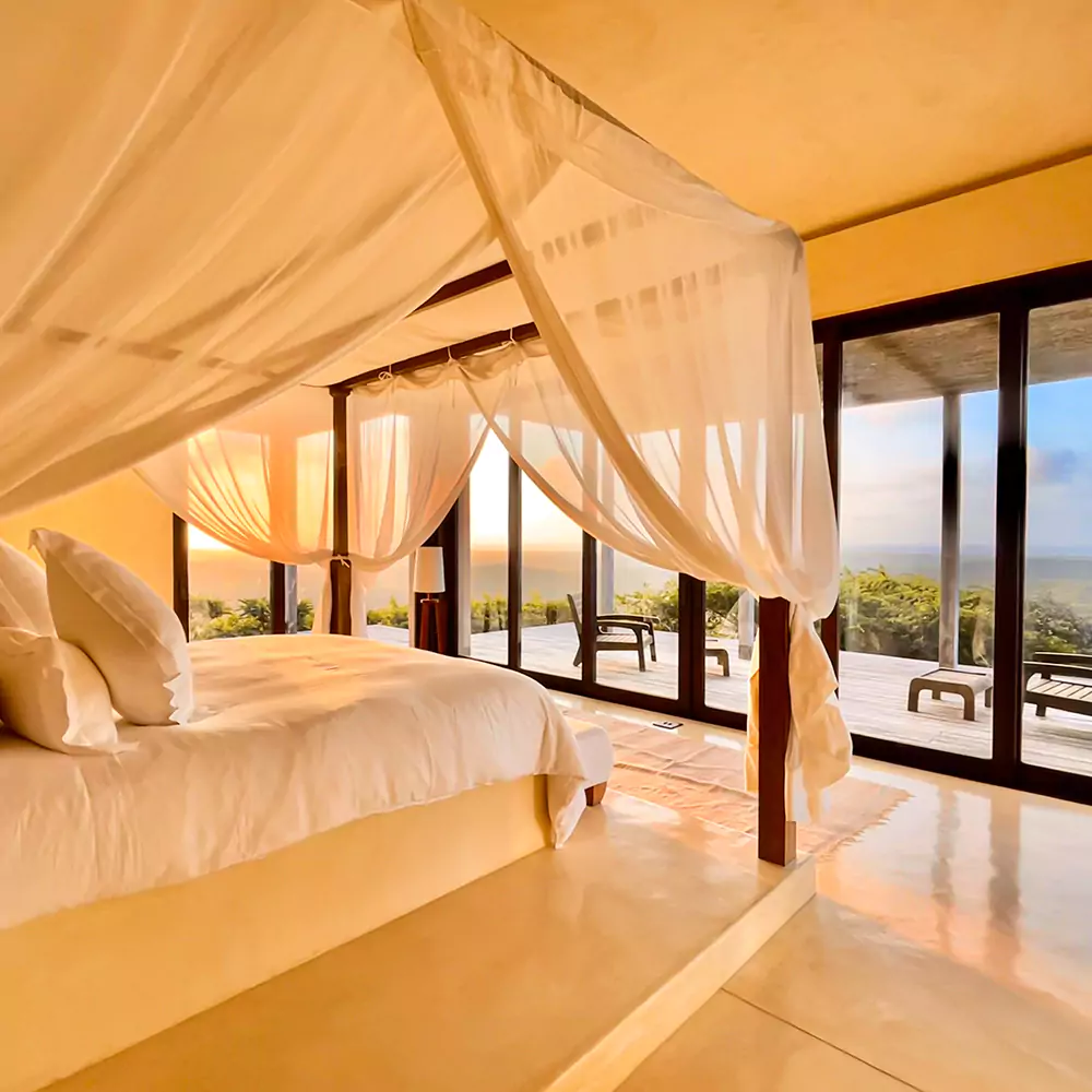 four poster bed with an ocean view at matalai house's master suite