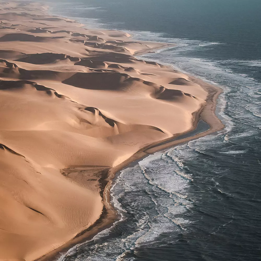 aerial view of the skeleton coast in namibia where desert meets the ocean